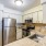Spacious and well lit kitchen with wood flooring and stainless steel appliances